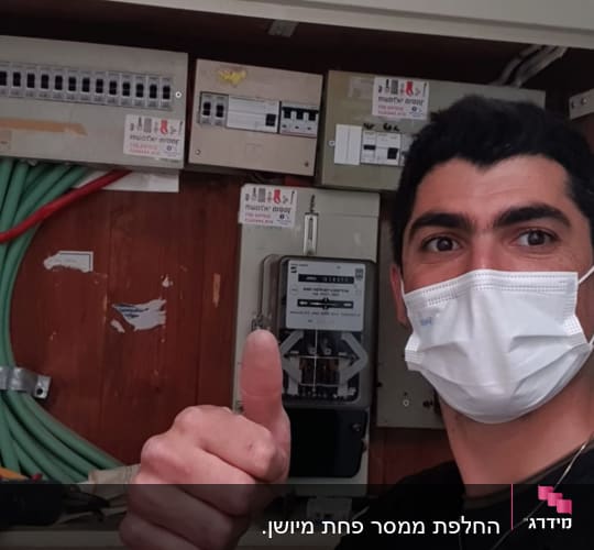 לוח חשמל עם כבלים ירוקים ואדומים, אדם עם מסכה
